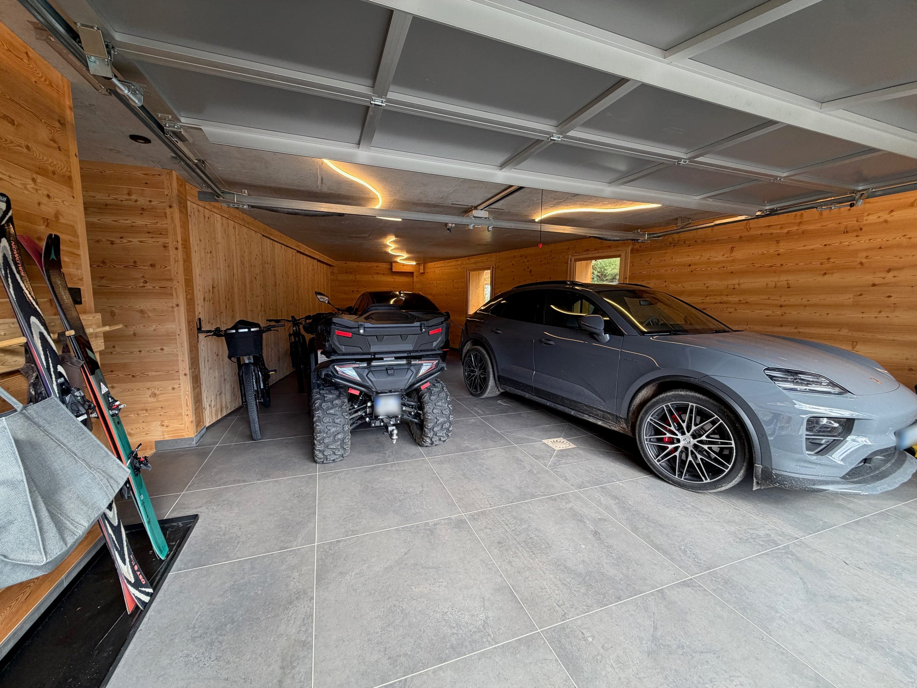Vue d'ensemble du garage : voiture, quad et vélos côte à côte
