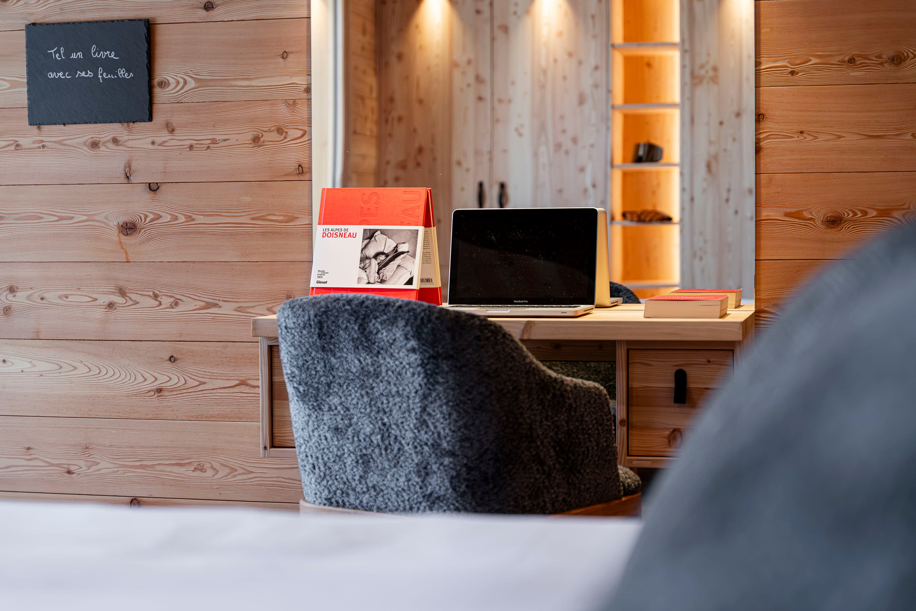 Bureau avec fauteuil gris, livres et ordinateur portable